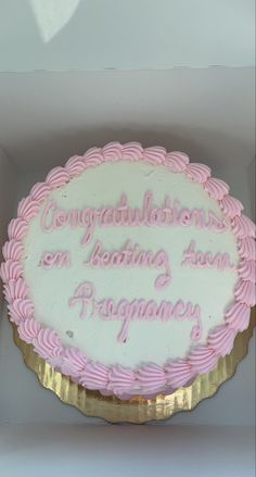 a pink and white cake in a box with congratulations written on the frosting inside