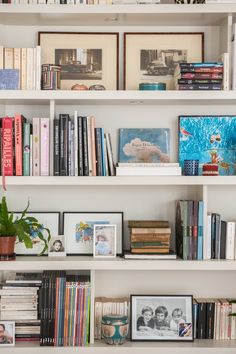 a bookshelf filled with lots of books and pictures on top of each shelf