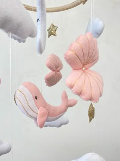 pink and white stuffed animals hanging from a mobile