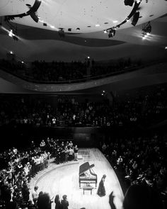 an audience is watching a concert with a grand piano