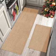 the kitchen is decorated for christmas and has two rugs in front of the stove