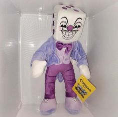 a purple and white stuffed animal with a tag in it's ear, sitting on a shelf