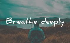 a man standing on top of a grass covered field next to a lake with the words breathe deeply