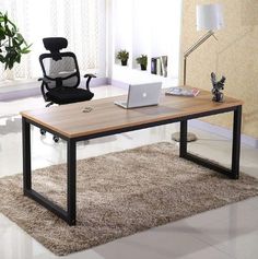 an office desk with a laptop on it and a chair next to it in front of a window