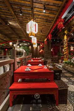 an indoor restaurant with red tables and benches