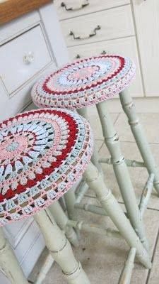 two crocheted stools sitting next to each other on a tiled floor in a kitchen