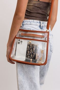 The Crystal Clear Carry-All Messenger Bag is perfect for your on-the-go needs. Keep your belongings safe and organized in this stylish and transparent bag. With its clear design, you'll never have to search for your items again. Stay chic and trendy with this fun and happy bag! #lovemyleto 100% PVC Imported Happy Bag, Earthy Chic, Kimono Sweater, Transparent Bag, Bralette Tops, Top Graphic Tees, Guitar Strap, Tank Top Cami, Cami Tanks