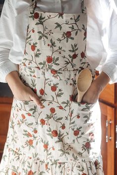 a person wearing an apron and holding a wooden spoon in their right hand with both hands