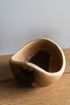 a wooden bowl sitting on top of a wooden table