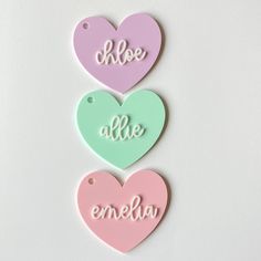 three pastel heart shaped tags with the words hello alle emelo written on them