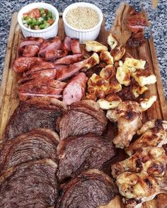 a wooden tray with meats and vegetables on it