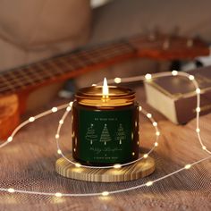 a candle that is sitting on a table next to some string lights and a guitar