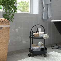 a bath room with a tub and a shelf next to a plant on the floor