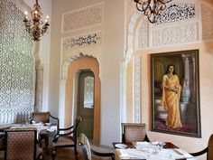 an ornately decorated dining room with chandeliers and paintings on the walls,