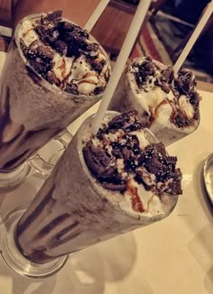 three ice cream sundaes sitting on top of a table