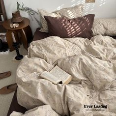 an unmade bed with a book on it