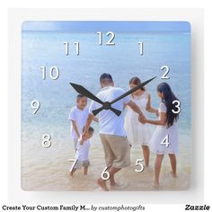 a family holding hands while standing in the water at the beach with their feet in the sand