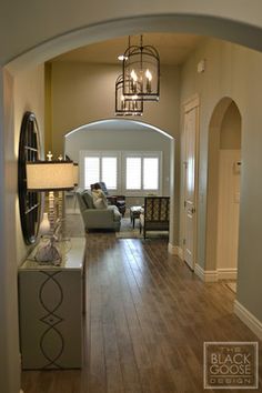 an archway leads to the living room and dining room in this modern home with wood flooring