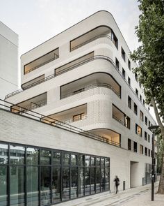 the building has many windows and balconies on each floor, as well as glass doors