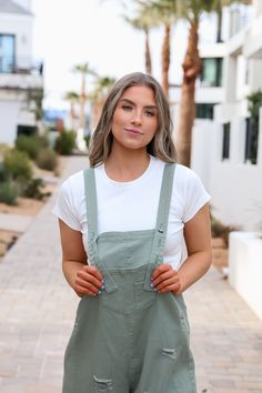 Introducing the Frankie Denim Overalls in Sage. Designed with adjustable straps, an oversized fit, and distressed details, these sage green bib overalls offer both style and comfort. The wide leg pant gives a trendy touch, making them a must-have for any fashion-forward individual. Model Measurements: Hips 40.5” Waist 27.5” Bust: 34”, Height 5’7.5, wearing a size small Material: 100 Cotton Measurements XS: Hips: 42"| Length: 44" (taken from top of front of overalls to ankle cuff) S: Hips: 42"| L Trendy Spring Shortalls With Adjustable Straps, Casual Olive Jumpsuits And Rompers For Spring, Green Cotton Utility Overalls, Casual Green Shortalls With Pockets, Trendy Shortalls With Suspenders For Spring, Trendy Spring Shortalls With Suspenders, Spring Utility Overalls For Everyday, Utility Overalls For Everyday Spring Wear, Utility Style Spring Overalls For Everyday