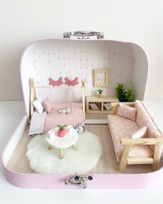 a doll house with furniture and accessories in the shape of a suitcase, including a bed