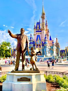 there is a statue of walt and mickey mouse in front of the disney world castle