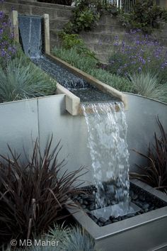 a water fountain in the middle of a garden