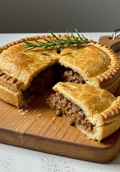 a meat pie is cut in half on a cutting board