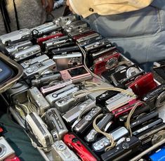 many different types of cameras are on display at an outdoor flea market, including one for sale