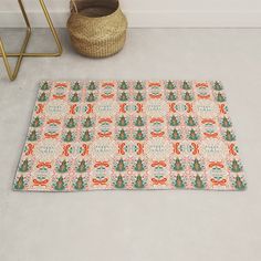 a rug with an orange and blue pattern on it next to a basket, chair and planter