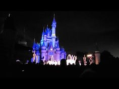 people are standing in front of the castle at night