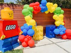 a lego themed birthday party with balloons and balloon arch for kids to play in the yard