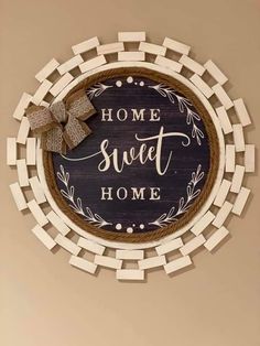 a wooden sign that says home sweet home with a bow hanging on the wall above it