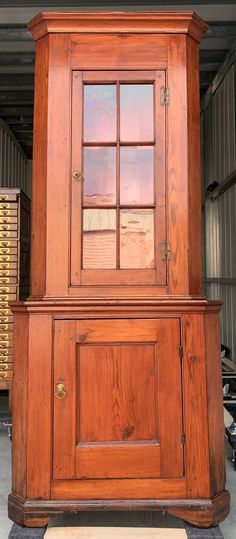 an old wooden grandfather clock on display in a warehouse