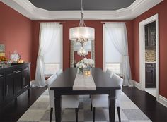 a dining room with blue walls and white curtains