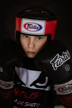 a young boy with boxing gloves on his head