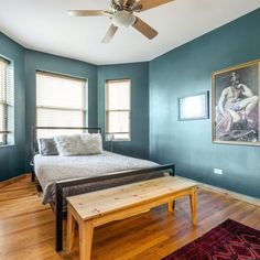 a bedroom with blue walls and wooden floors