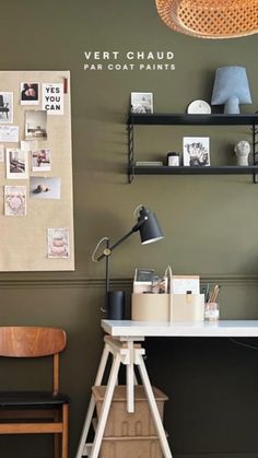 a desk with a lamp and some pictures on the wall