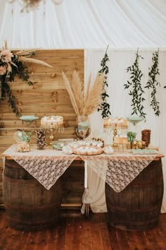 a table topped with cakes and cupcakes on top of a wooden barrel