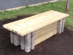 a bench made out of cinder blocks sitting in the dirt