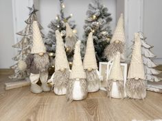 small knitted gnomes in front of christmas trees