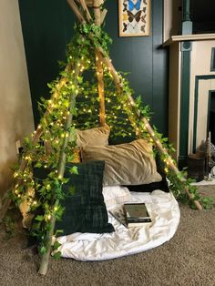 a bed that has some lights on it in the middle of a room with a fireplace