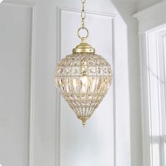 a chandelier hanging from the ceiling in a room with white walls and windows