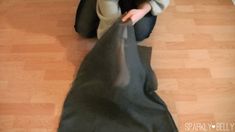 a person kneeling on the floor with a black bag