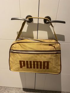 Thank you for visiting Beats and Treats . A  tan and brown   vintage ( Unused NOS ) Puma Shoulder Bag Manufactured in the 1970's. I have located 4 of these bags , they have been stored flat in  their plastic bags . If you look at the way the " M" has two indents on the top , that was the logo for the mid to late 1970's. They have that classic shape that is wider at the bottom than the top . Meassurements are 15" X 10" x 7" at the bottom narrowing to 5" at the top. The condition is as new inside Brown Logo, Sports Bags Gym, Browning Logo, Sports Gym, Brown Vintage, Gym Bags, Sport Gym, Team Sports, Canvas Shoulder Bag