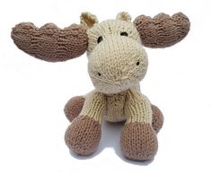 a knitted moose toy sitting up against a white background