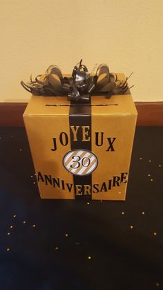 a yellow box with black ribbon around it that says joyeux 30th anniversaire