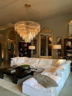 a living room filled with furniture and a large chandelier hanging from the ceiling