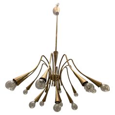 a brass chandelier with six lights hanging from it's center and eight bulbs on each end