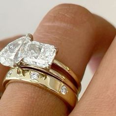 a woman's hand with two gold wedding rings and one diamond ring on her finger